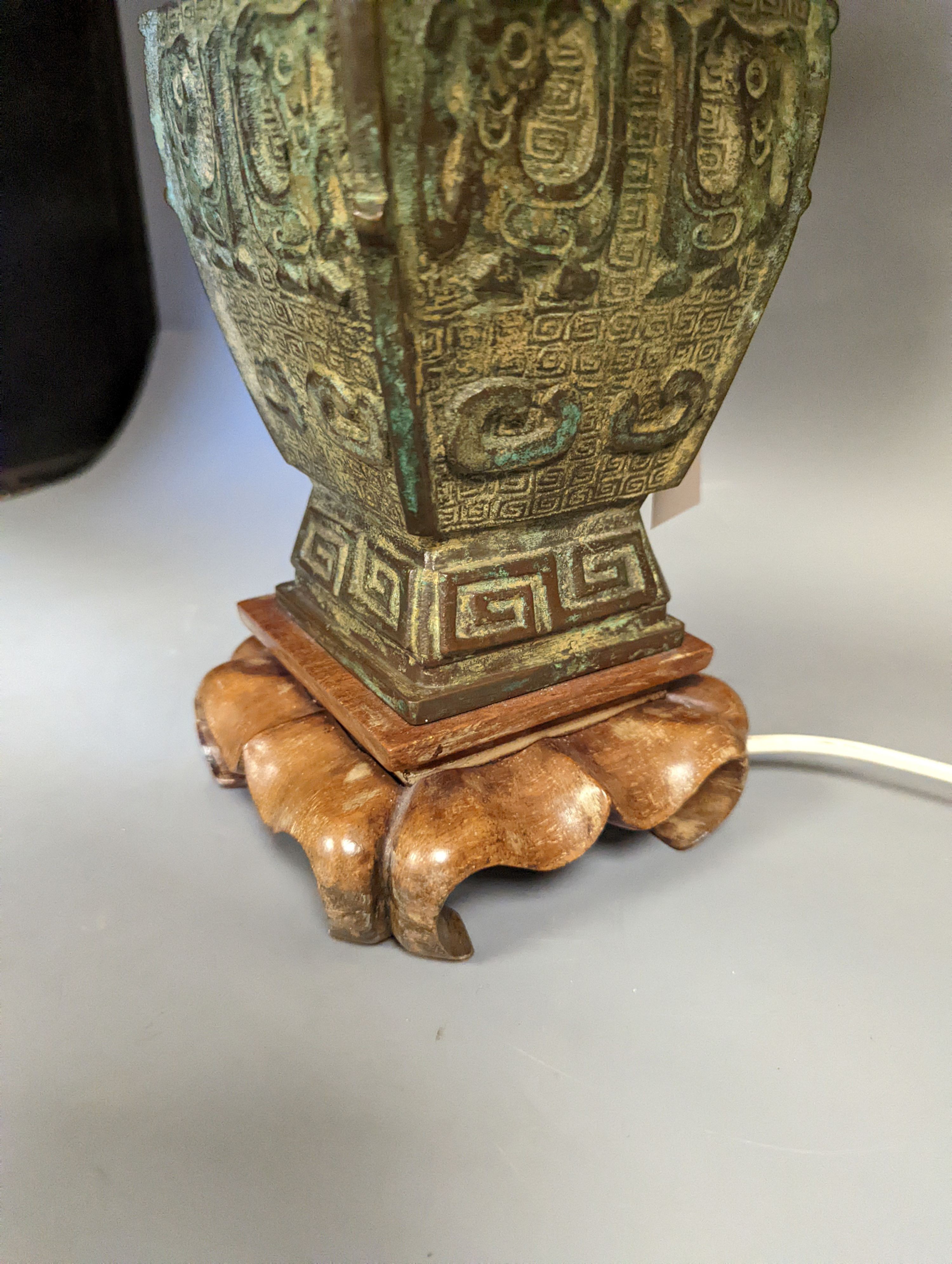 A pair of Chinese archaistic bronze lamps, 37 cms high not including shades or light fitting.
